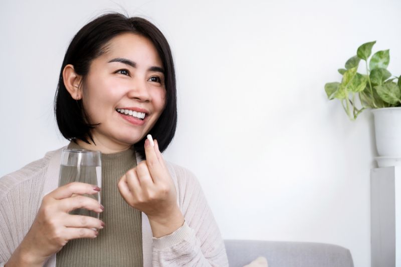 Woman taking medicine with water