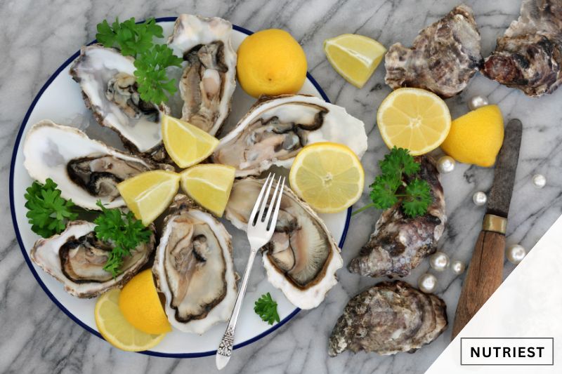 A plate of fresh oysters arranged in a circular pattern, adorned with lemon wedges and parsley sprigs.