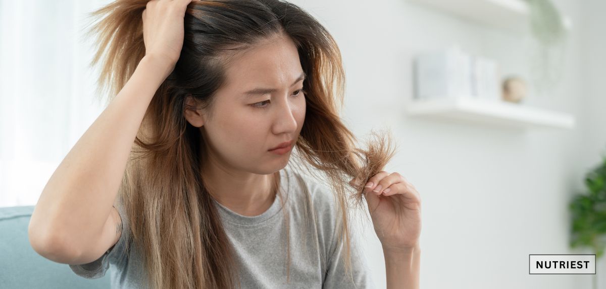 Woman checking brittle hair, illustrating benefits of the best iron supplement for anemia
