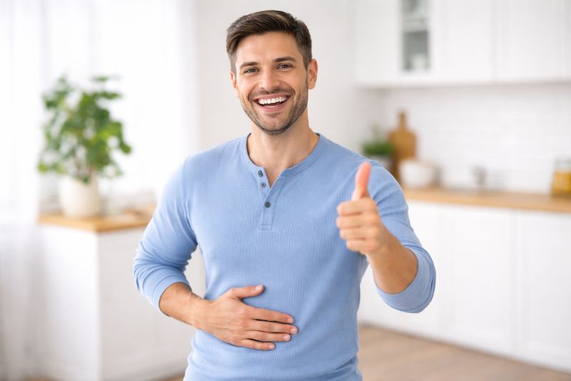 Man smiling and holding stomach, despite feeling worse after taking iron supplements